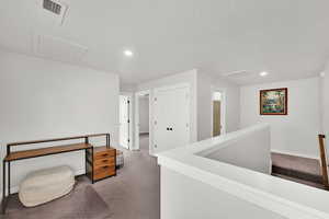 Hallway with dark colored carpet