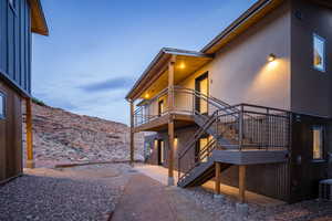 Property exterior at dusk featuring a deck with mountain view and a patio