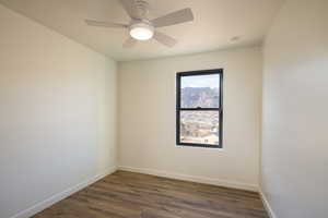 Spare room featuring dark hardwood / wood-style floors and ceiling fan