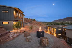 Yard at dusk featuring a balcony, an outdoor fire pit, and a mountain view