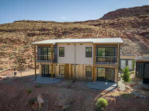 Back of house with a mountain view and a patio