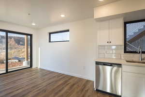 Kitchen featuring white cabinetry, dishwasher, plenty of natural light, and sink