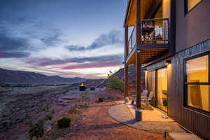 Yard at dusk featuring a mountain view and a patio area