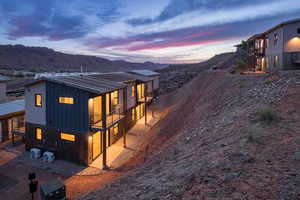 Property exterior at dusk featuring a balcony and a mountain view