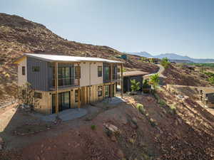 Rear view of house with a mountain view, a sunroom, and a patio