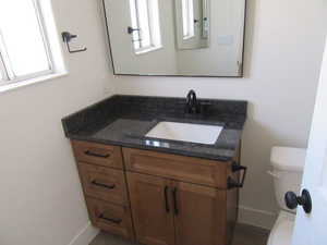 Bathroom featuring a healthy amount of sunlight, vanity, and toilet