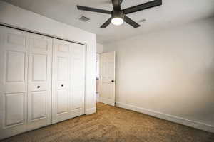 Unfurnished bedroom with carpet flooring, ceiling fan, and a closet