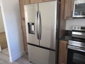 Kitchen featuring stainless steel appliances and light hardwood / wood-style floors