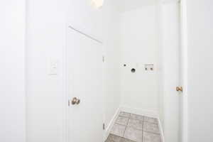 Clothes washing area featuring washer hookup, light tile patterned floors, and hookup for an electric dryer