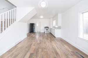 Unfurnished living room featuring sink and light hardwood / wood-style flooring