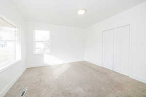 Unfurnished bedroom with carpet and a closet