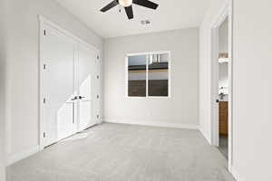 Unfurnished bedroom with light colored carpet and ceiling fan