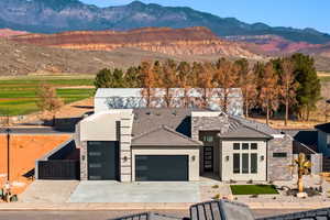 View of front of home with a mountain view and a garage