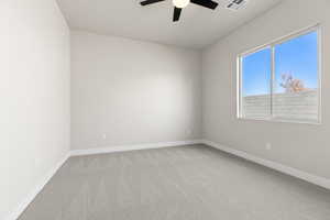 Carpeted empty room with ceiling fan