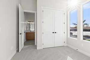 Unfurnished bedroom featuring light colored carpet and a closet