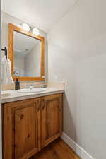 Bathroom with vanity, hardwood / wood-style floors, and a textured ceiling