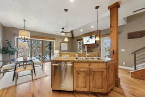 Kitchen with hanging light fixtures, vaulted ceiling, sink, and stainless steel dishwasher