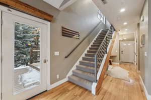 Stairs with an inviting chandelier and hardwood / wood-style floors