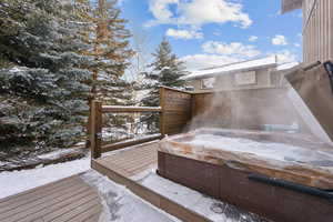 Snow covered deck featuring an outdoor hot tub