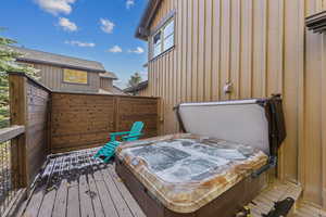 Wooden deck featuring a covered hot tub