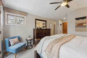 Bedroom with carpet floors, vaulted ceiling, and ceiling fan