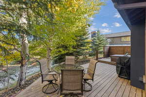 Wooden terrace featuring a grill