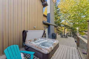 Wooden deck featuring a covered hot tub