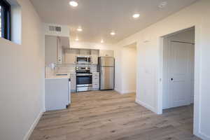 Kitchen with stainless steel appliances, tasteful backsplash, sink, and light hardwood / wood-style floors