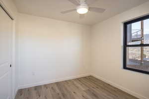 Unfurnished room with ceiling fan and light wood-type flooring