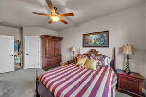 Carpeted bedroom featuring ceiling fan