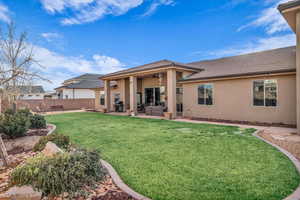 Rear view of house featuring a lawn, a patio, and ceiling fan