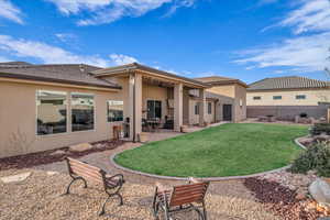 Rear view of property with a yard and a patio area