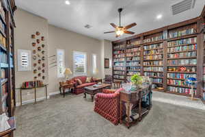 Sitting room with carpet, built in features, and ceiling fan