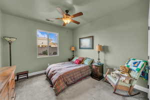 Carpeted bedroom featuring ceiling fan