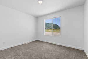 Empty room with a mountain view and carpet flooring