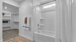 Bathroom featuring hardwood / wood-style flooring and shower / bath combo with shower curtain