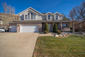 View of front facade with a garage and a front lawn