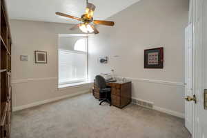 Office featuring vaulted ceiling, light carpet, and ceiling fan