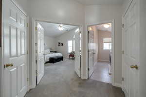 Corridor featuring lofted ceiling and light carpet