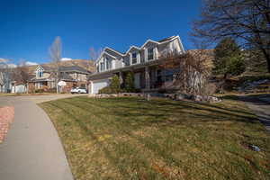 View of front facade featuring a garage and a front lawn