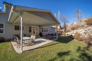 Back of house featuring a patio, a lawn, and french doors