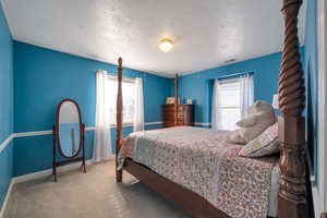 Bedroom with carpet floors and a textured ceiling