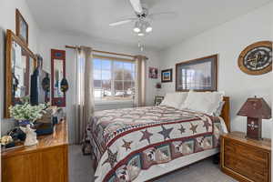 Carpeted bedroom featuring ceiling fan and a textured ceiling