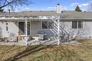 Back of house with a pergola, a lawn, and a patio