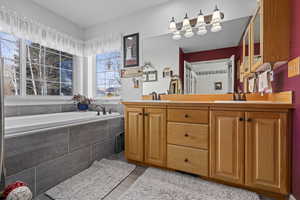 Bathroom with tiled tub and vanity