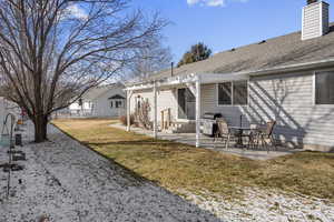 Back of house with a yard, a patio area, and a pergola