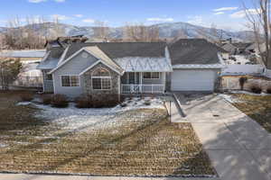 Ranch-style house featuring a mountain view, a garage, and covered porch