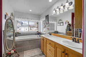 Bathroom with a relaxing tiled tub and vanity