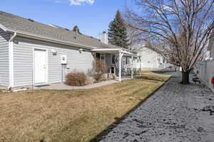 Back of house featuring a yard, a pergola, and a patio area