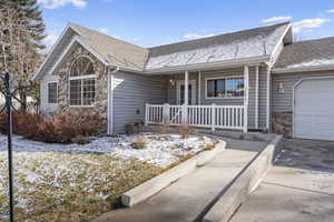 Single story home with a porch and a garage